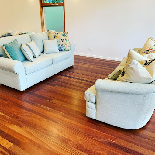 Pale upholstered sofas with patterned cushions on a timber floor